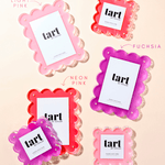 Set of pink and fuchsia 'tart' products on a beige background