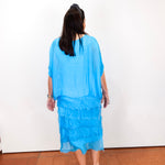Model styling the Gail tiered ruffle dress in turquoise with a lightweight, flowy design.
