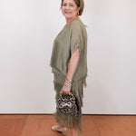 Woman wearing the Gail tiered ruffle dress in olive with a flowy silhouette and layered ruffle details.