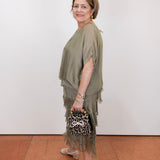 Woman wearing the Gail tiered ruffle dress in olive with a flowy silhouette and layered ruffle details.