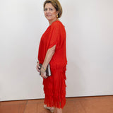 Woman wearing the Gail tiered ruffle dress in red with a flowy silhouette and layered ruffle details.