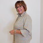 Woman wearing a patterned shirt against a plain background