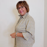 Woman wearing a patterned shirt against a plain background