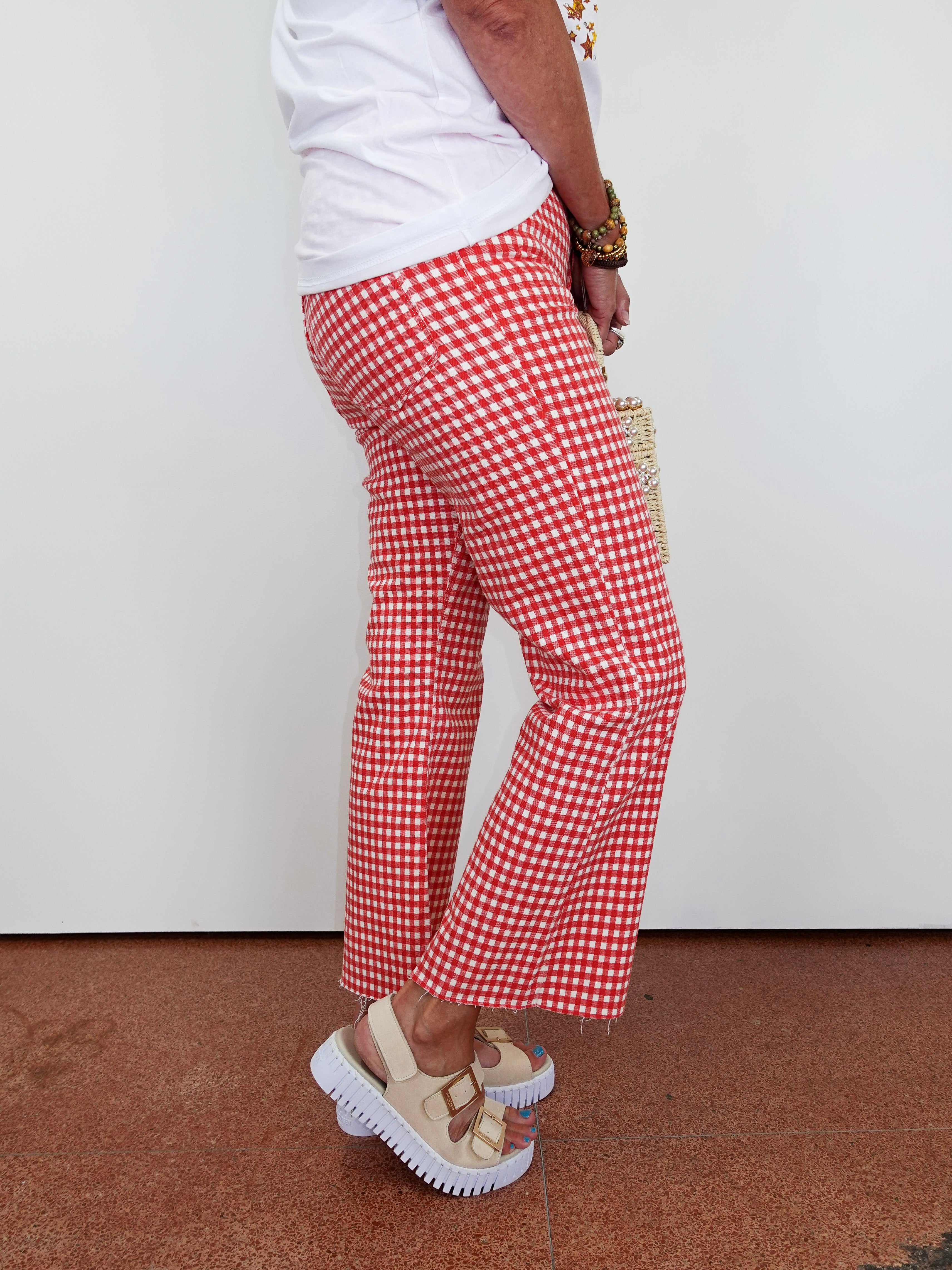 Person wearing red and white checkered pants with a plain background