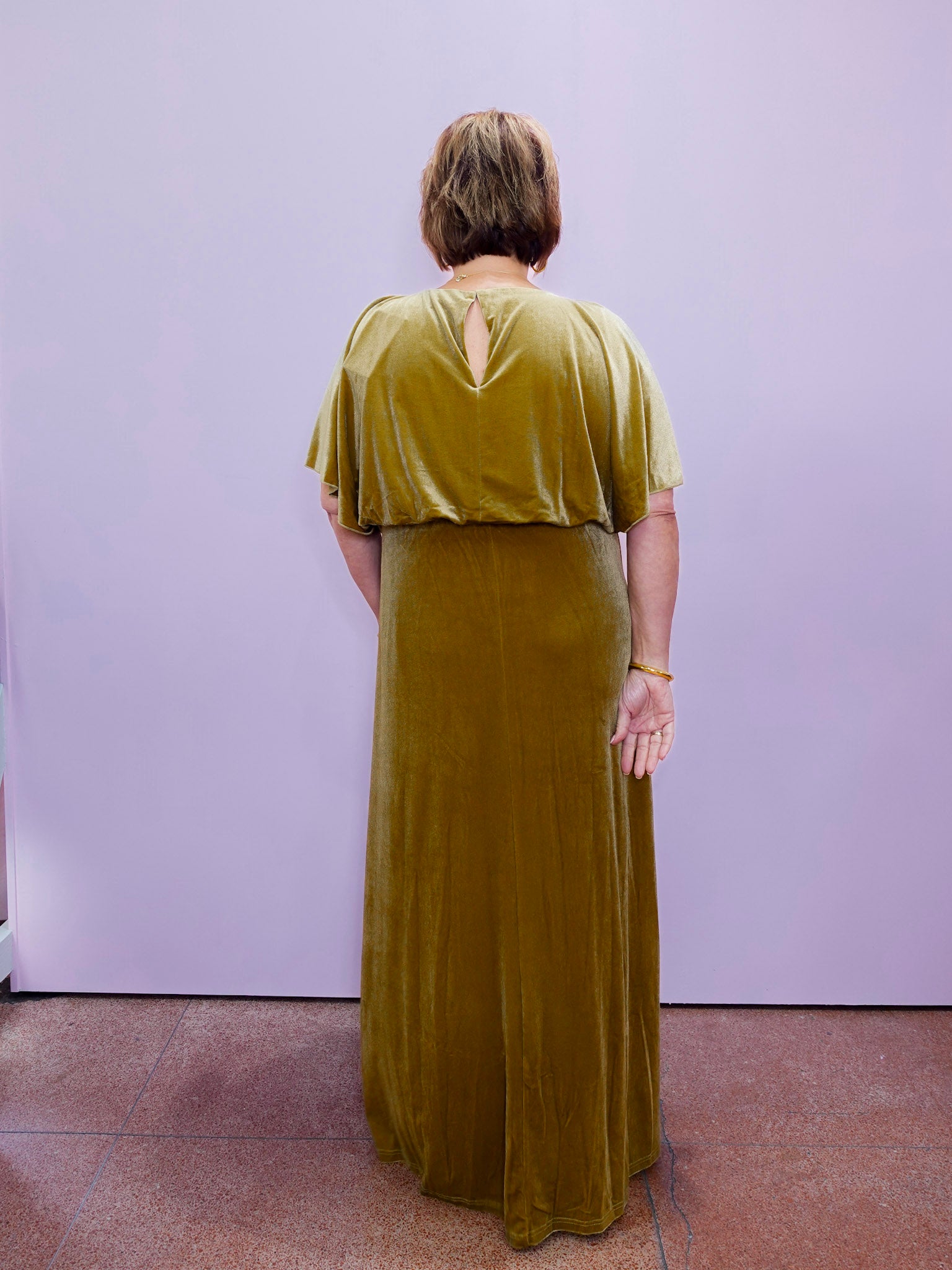 Gold velvet flutter sleeve maxi dress with a flattering waistline and slit hem, offering a chic and timeless evening style.