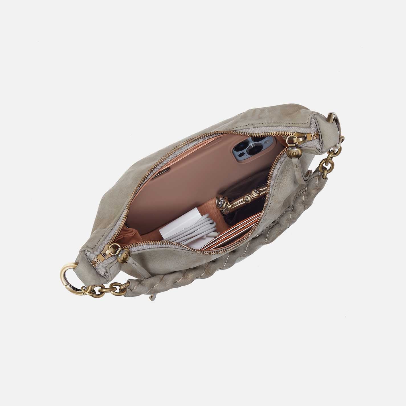 Beige handbag with gold chain strap on a white background