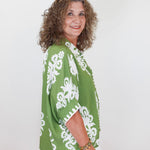 Woman wearing a green and white patterned kimono against a white background