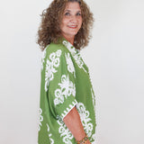 Woman wearing a green and white patterned kimono against a white background