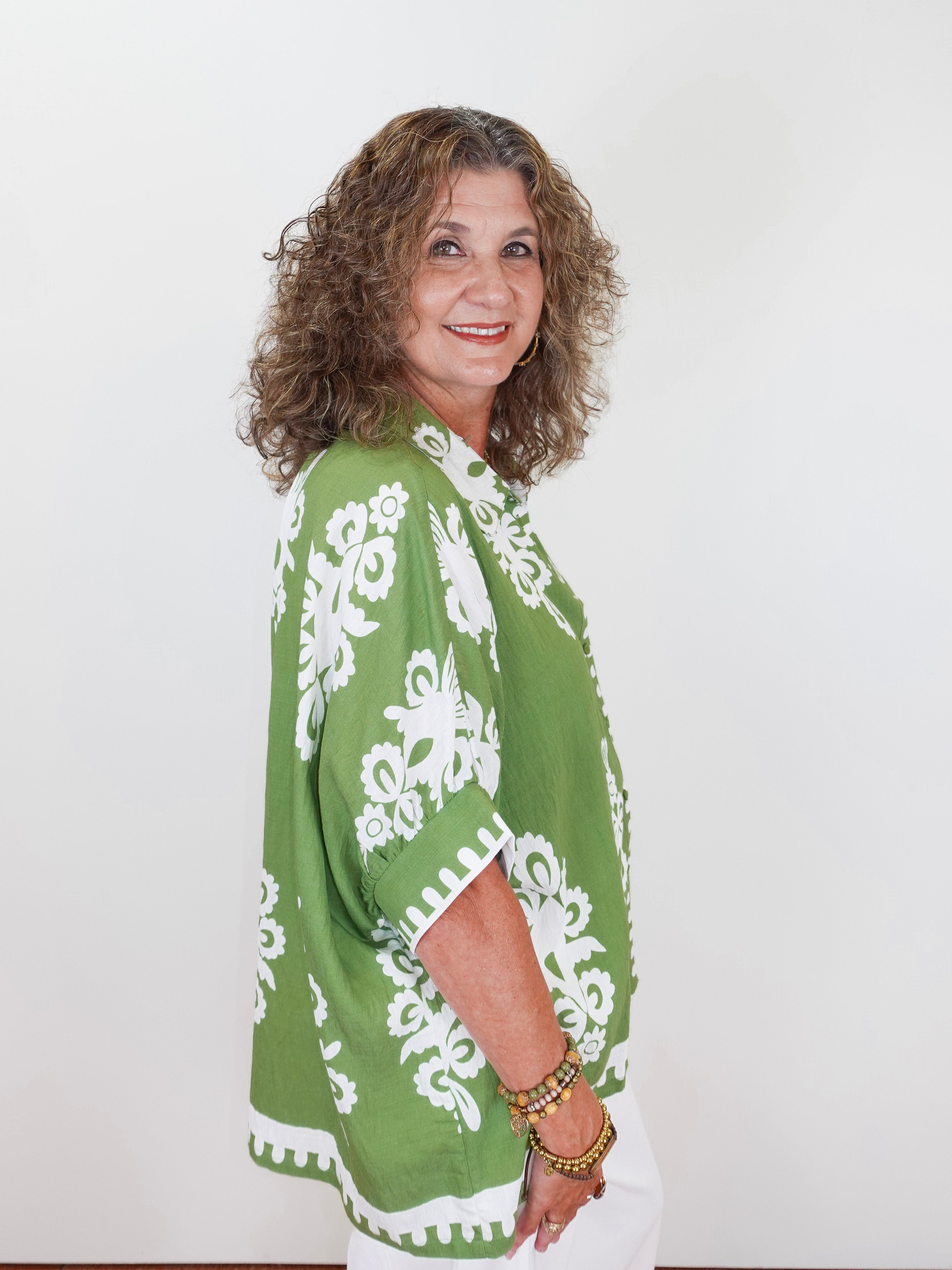 Woman wearing a green and white patterned kimono against a white background
