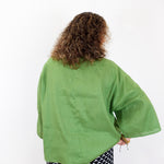Person wearing a green kimono-style garment on a white background