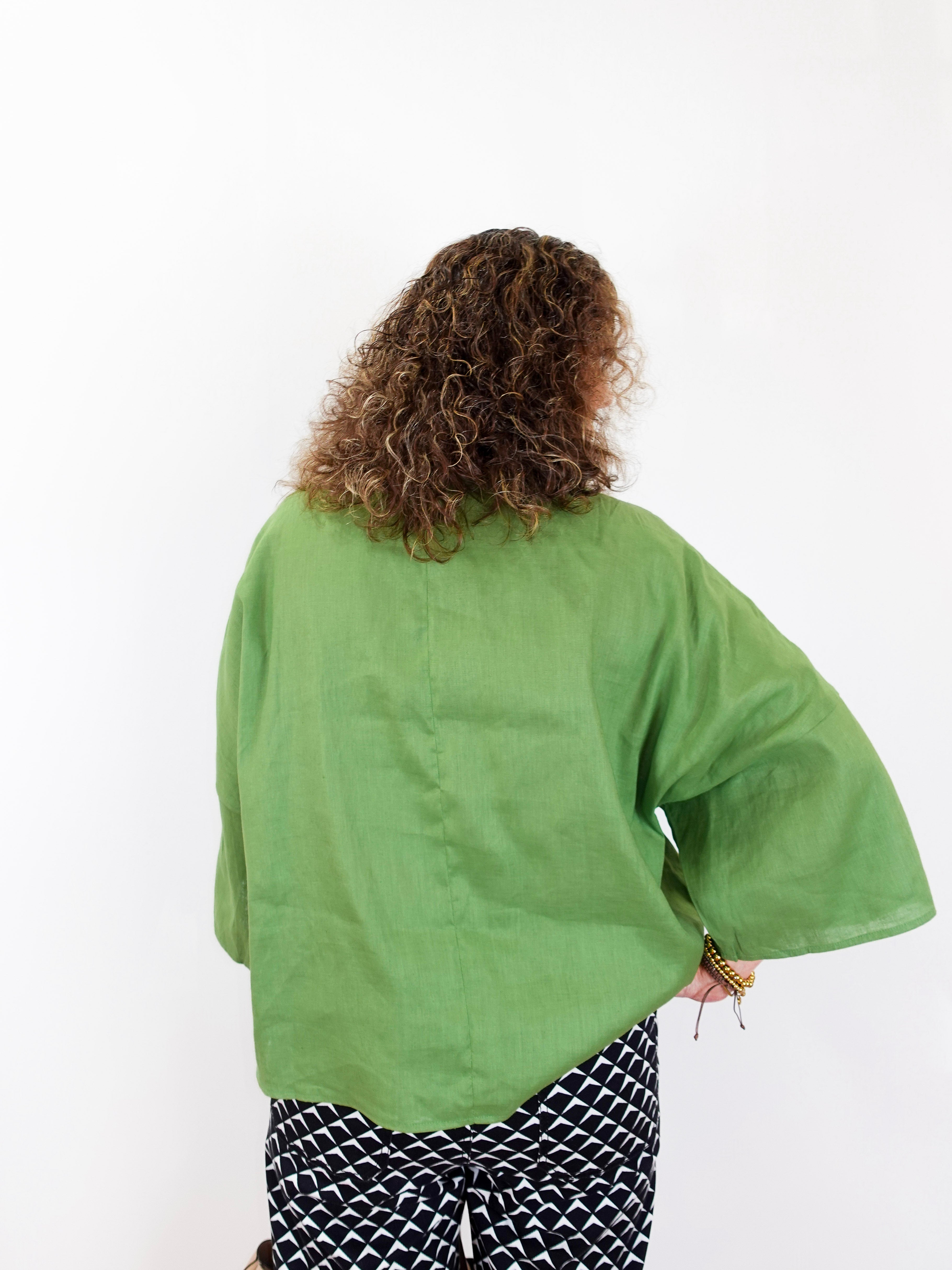 Person wearing a green kimono-style garment on a white background