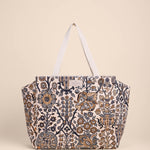 Patterned tote bag with white handles on a beige background