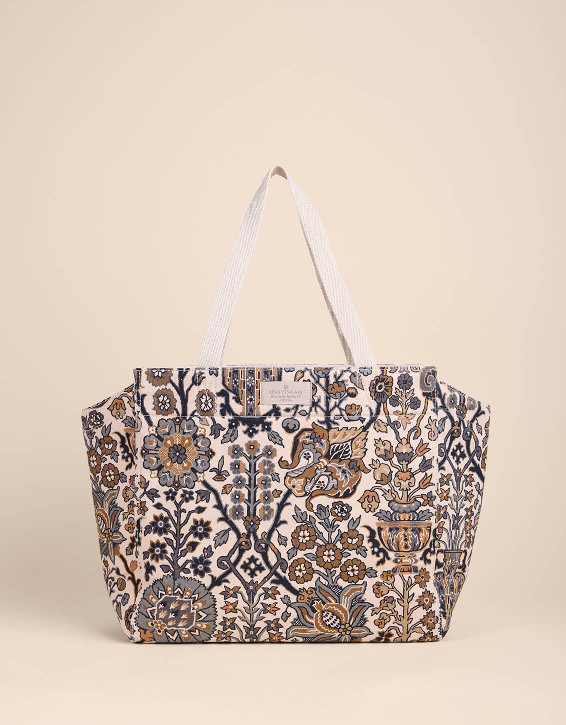 Patterned tote bag with white handles on a beige background