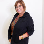 woman wearing a black jacket against a white background. 