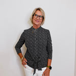 Person wearing a black and white striped shirt with a white background