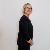 Person wearing a black outfit against a plain background