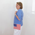 Woman holding a handbag with an American flag design against a white background