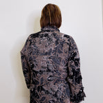 Person wearing a floral patterned blouse against a white background