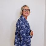 Person wearing a blue floral shirt against a white background