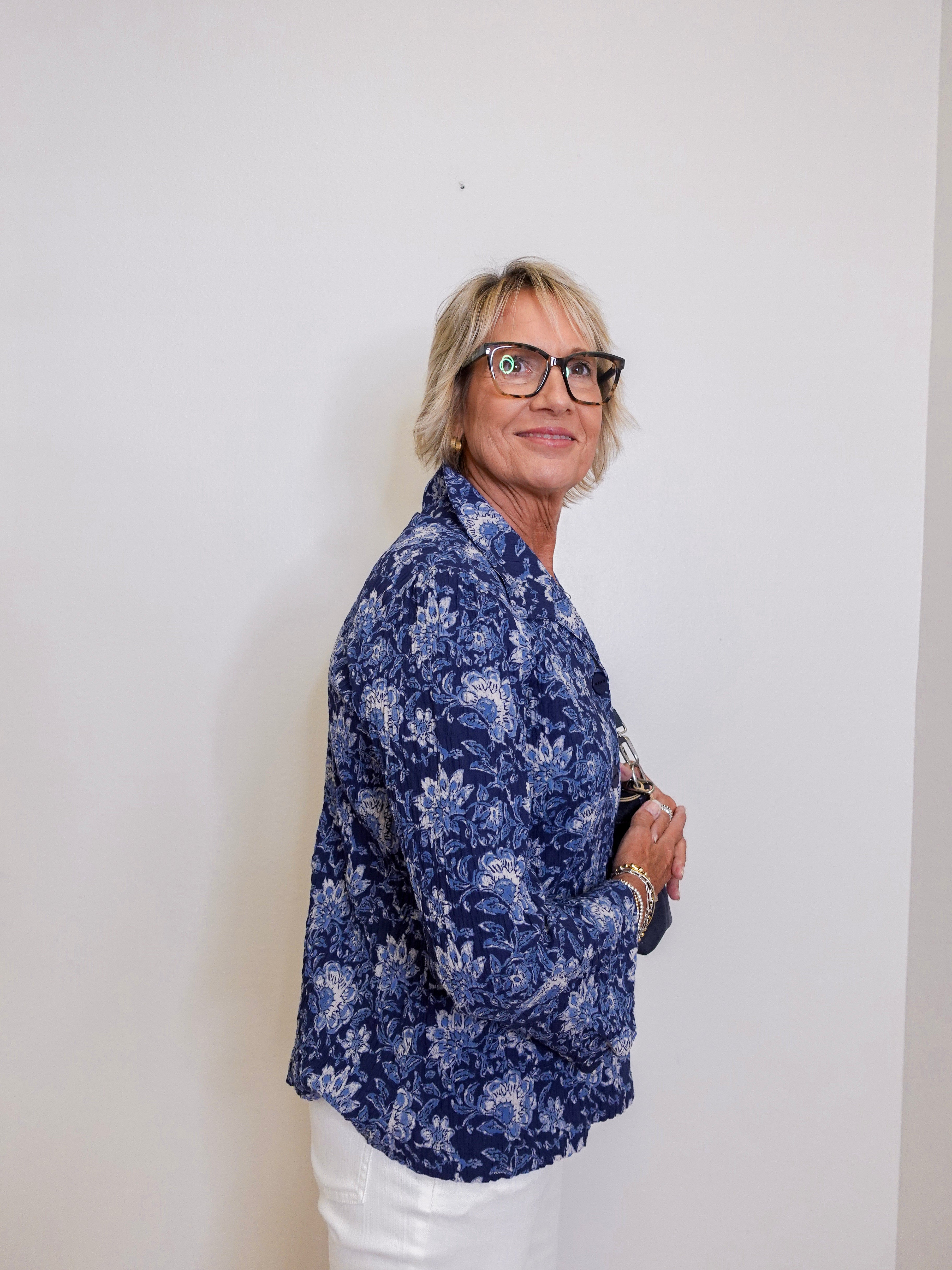Person wearing a blue floral shirt against a white background