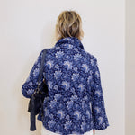 Person wearing a blue floral shirt against a white background