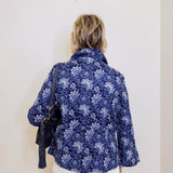 Person wearing a blue floral shirt against a white background