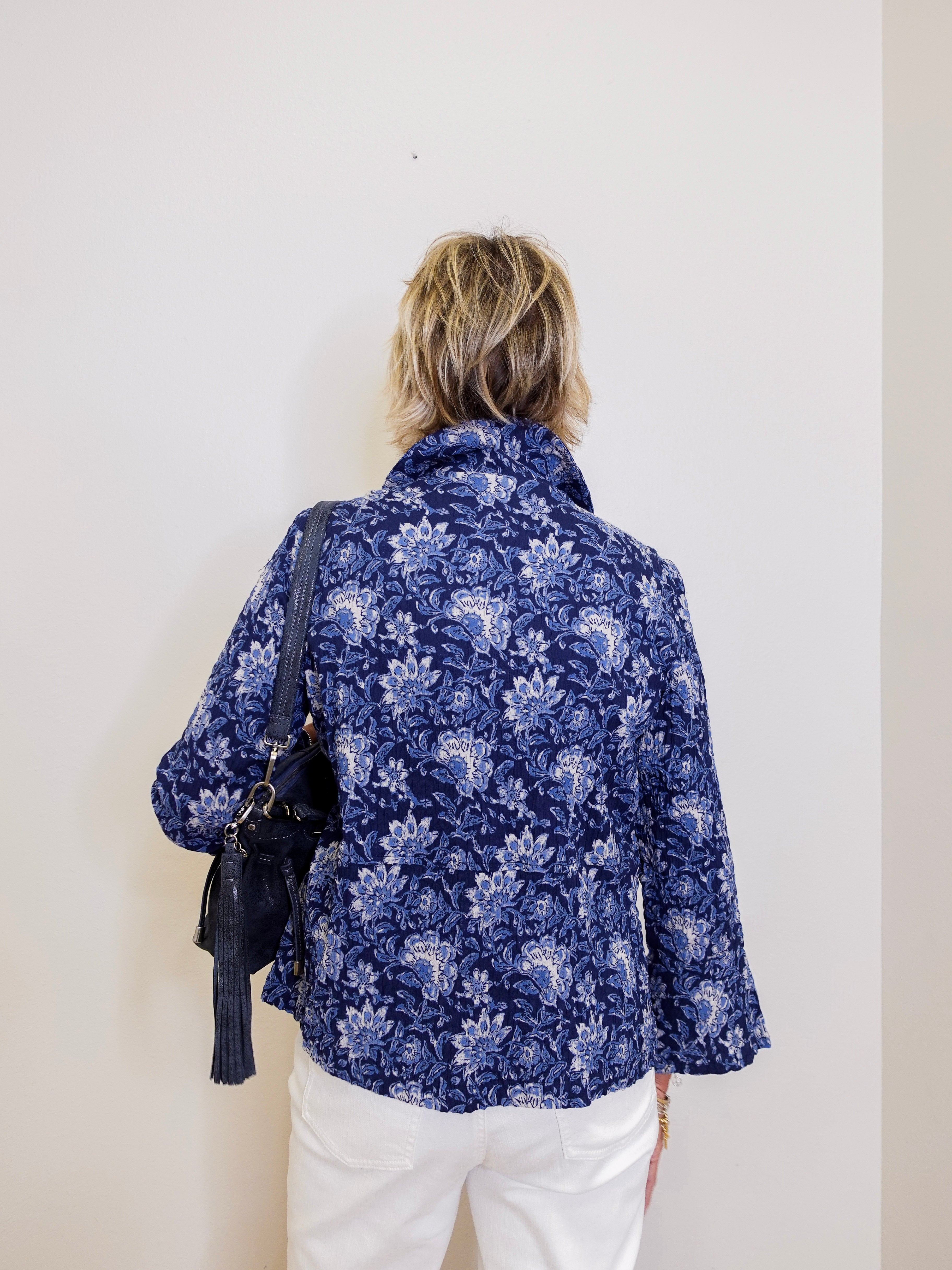 Person wearing a blue floral shirt against a white background