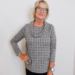 Woman wearing a patterned sweater against a plain background