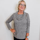 Woman wearing a patterned sweater against a plain background