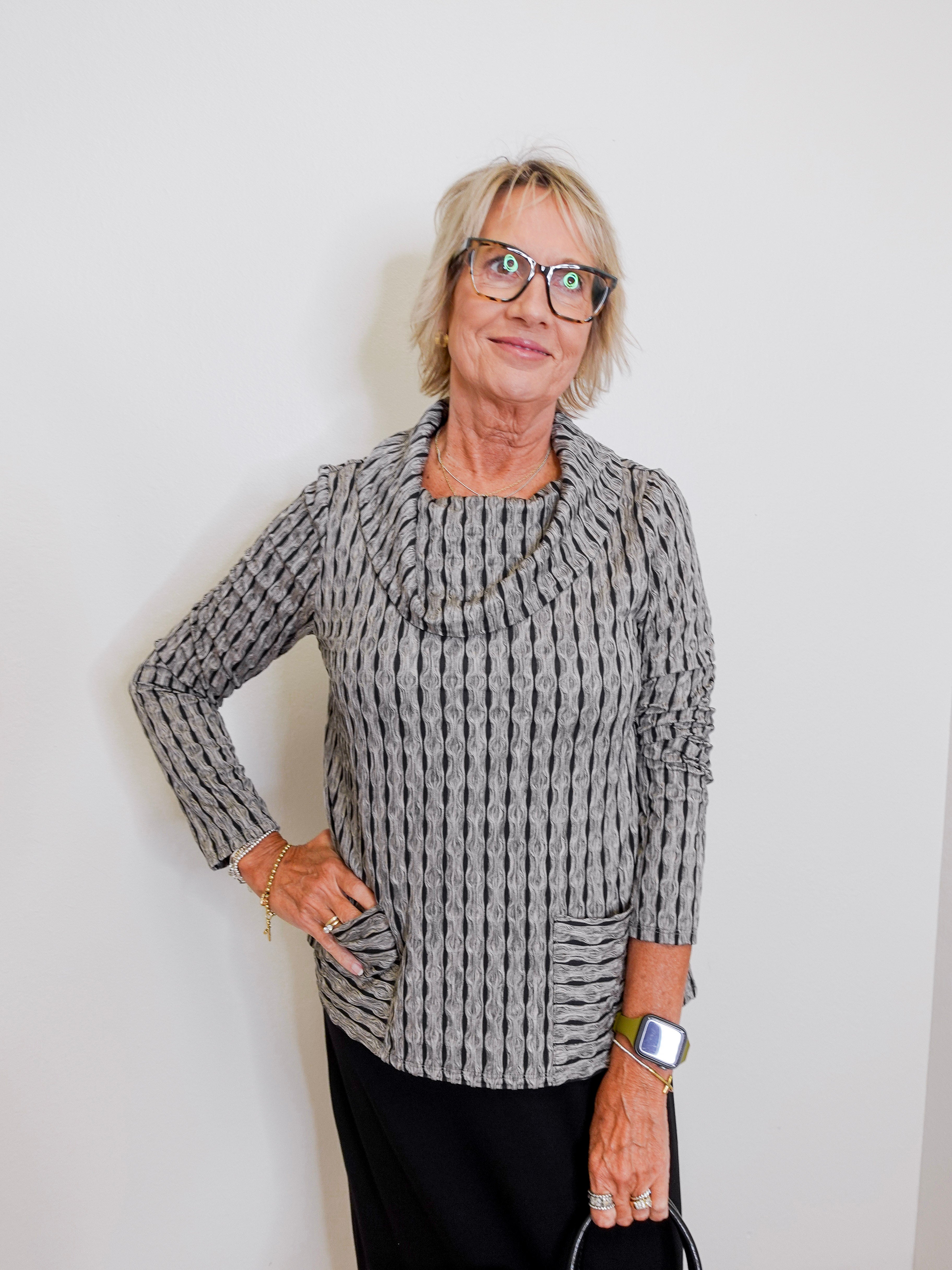 Woman wearing a patterned sweater against a plain background