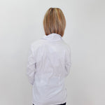 Person wearing a white lab coat against a plain background