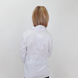Person wearing a white lab coat against a plain background