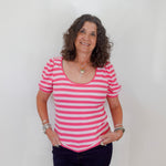Woman wearing a pink and white striped shirt against a plain background
