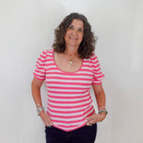Woman wearing a pink and white striped shirt against a plain background