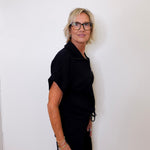 Person wearing a black outfit against a white background