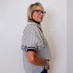 Person wearing a black and white striped shirt against a plain background