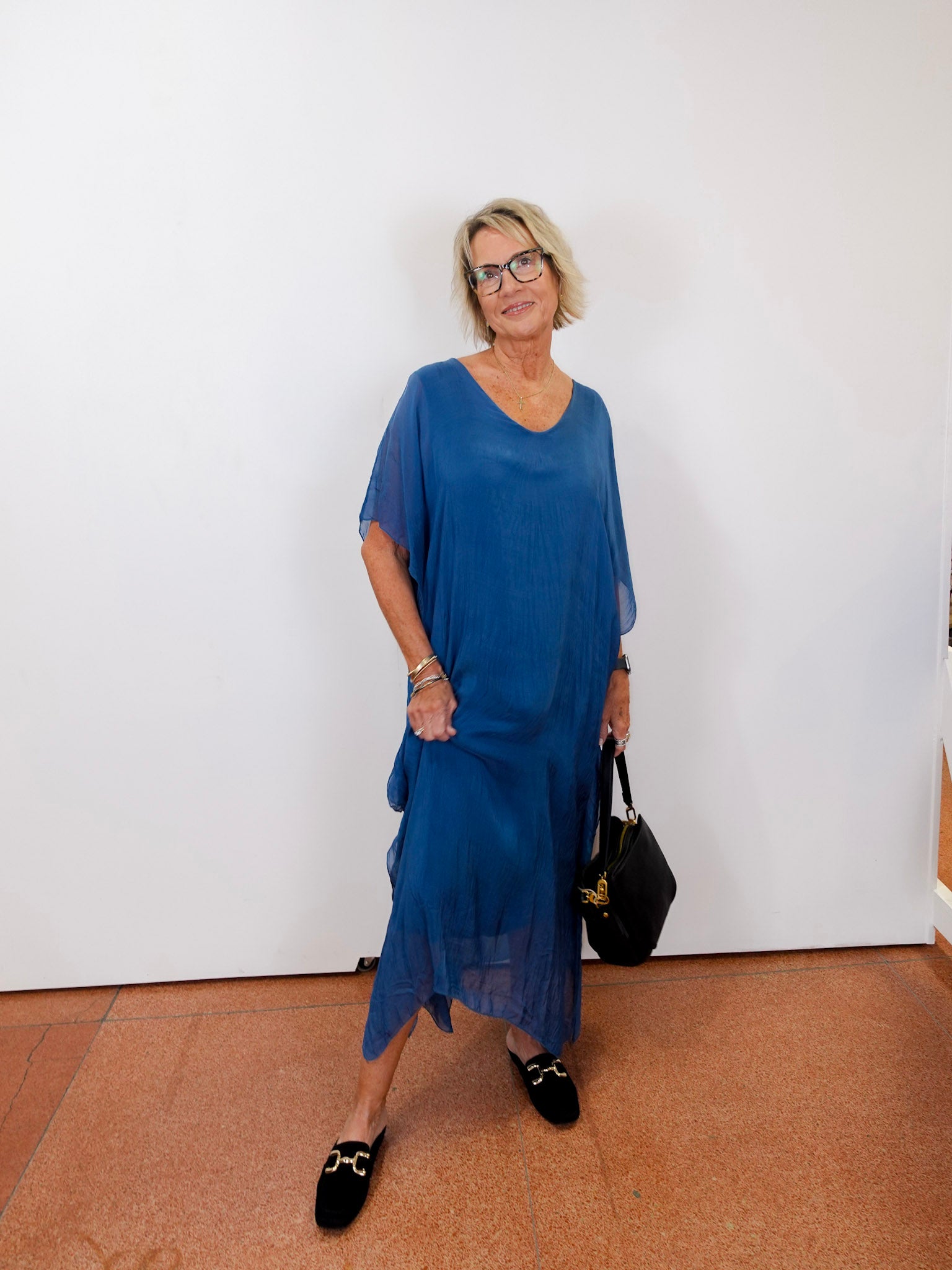 model wearing the helen silk kaftan long dress in blue with a flowy silhouette