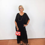 model wearing the helen silk kaftan long dress in black with a flowy silhouette