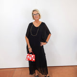 model wearing the helen silk kaftan long dress in black with a flowy silhouette