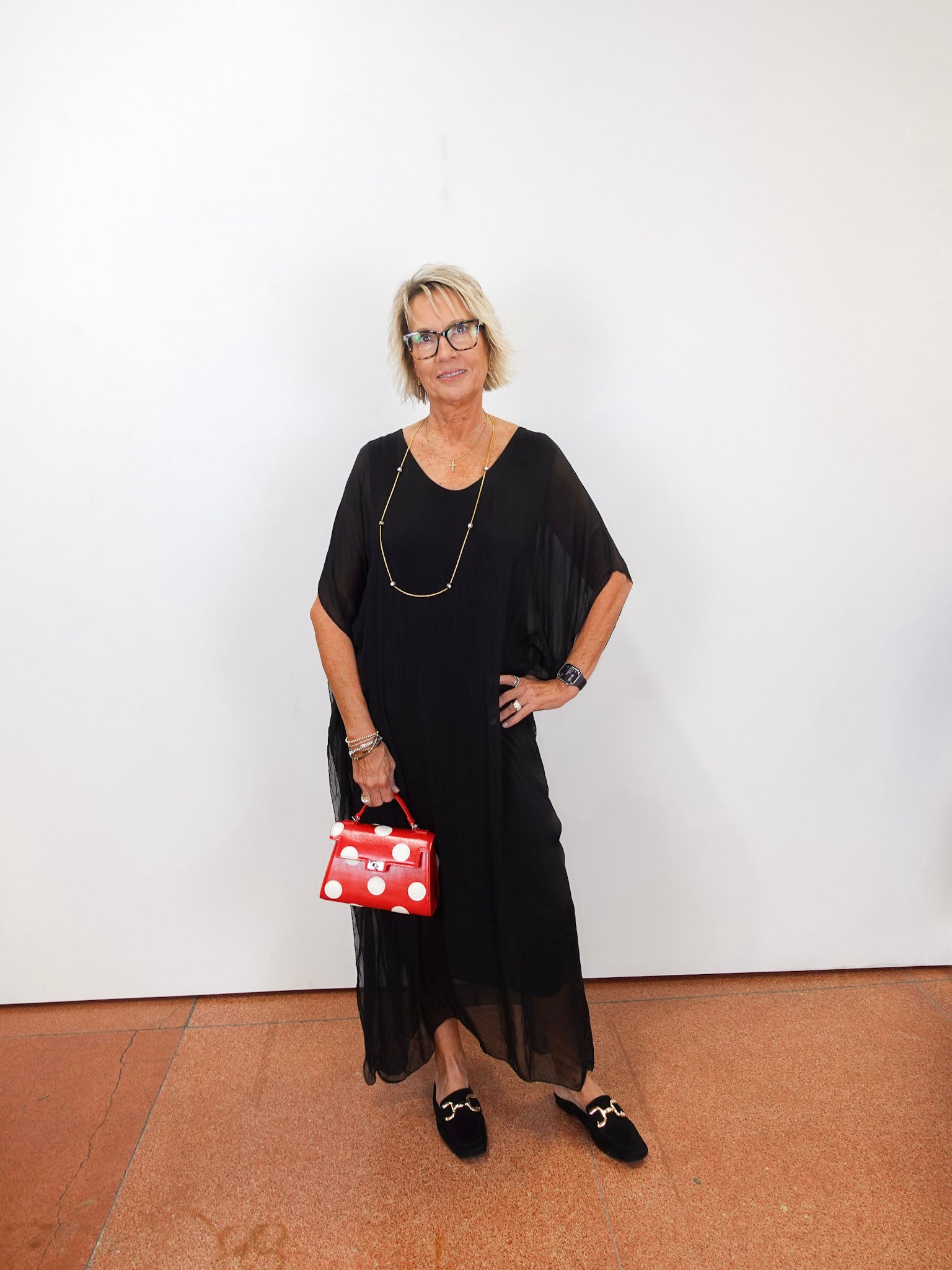 model wearing the helen silk kaftan long dress in black with a flowy silhouette