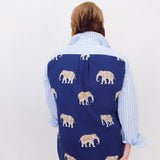 Person wearing a blue vest with elephant pattern over a striped shirt on a white background