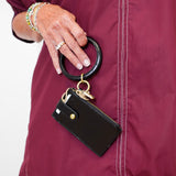 Person wearing a maroon jacket with a black keychain attached to it.