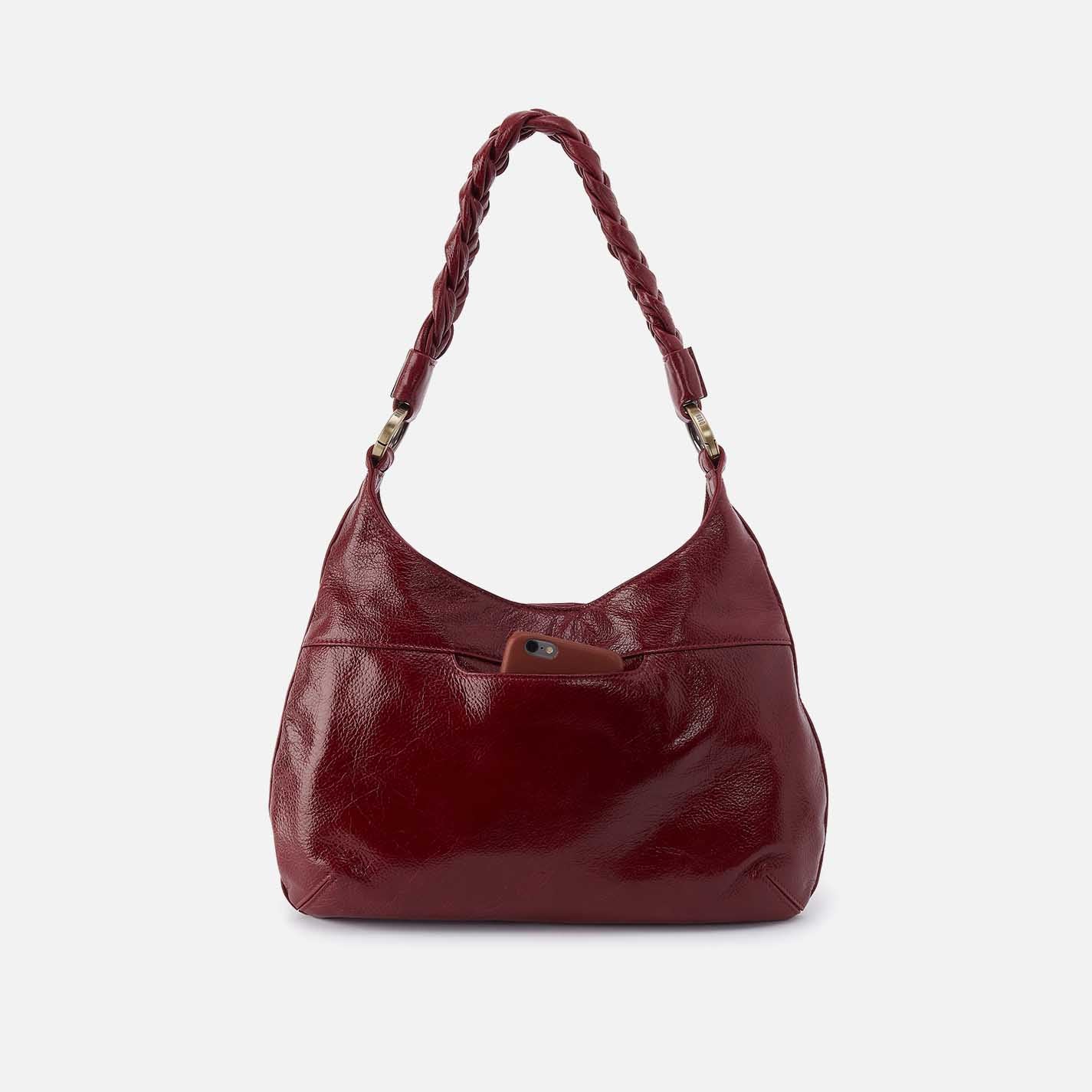 Red handbag with braided handle on a white background