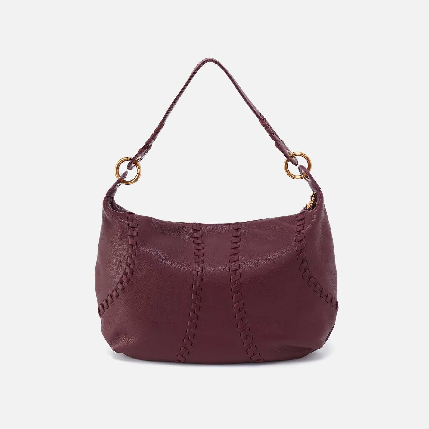 Maroon handbag with gold accents on a white background