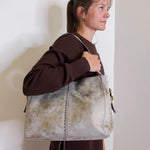 woman wearing the hobo bag render shoulder bag against a white wall.