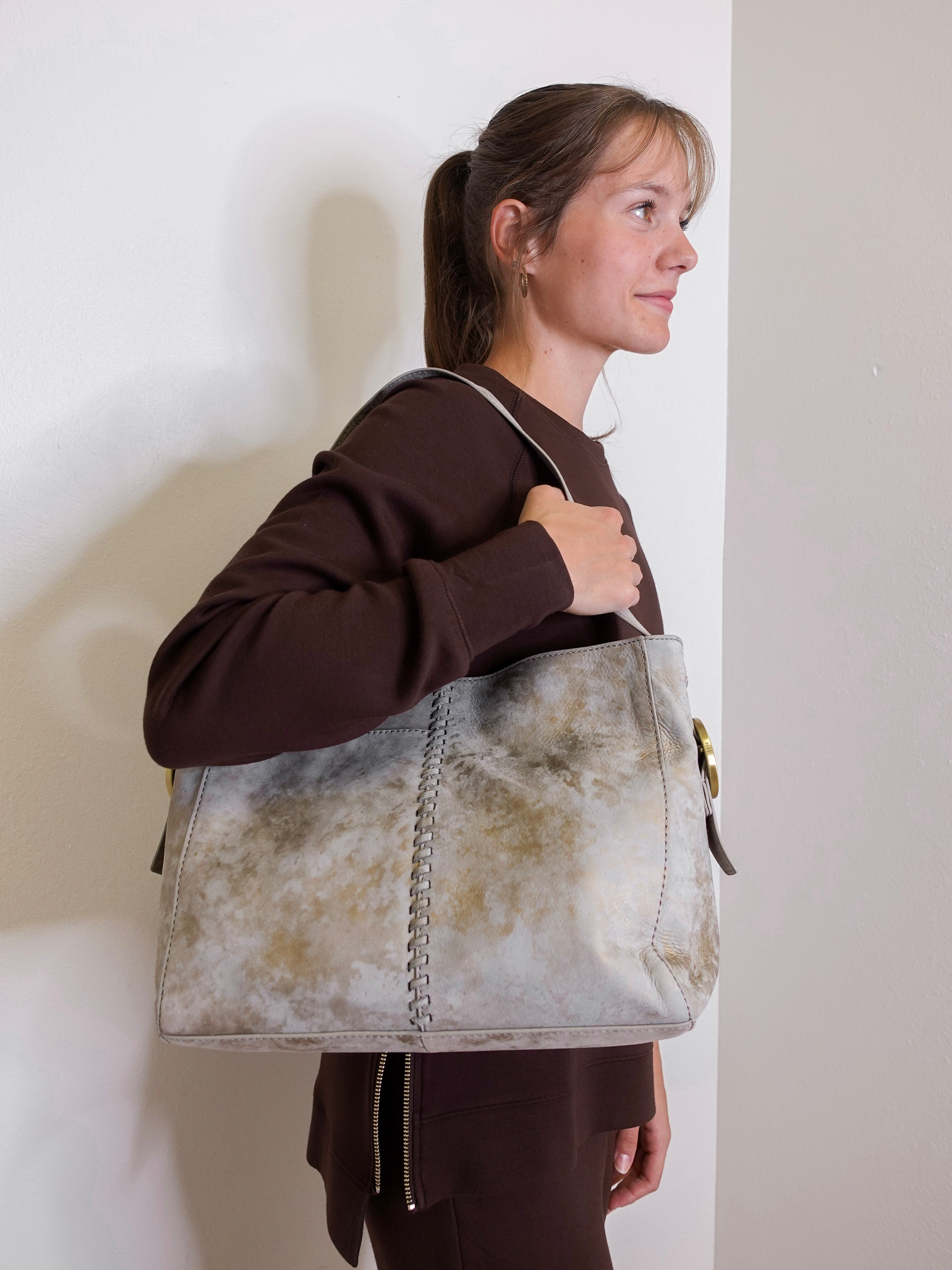 woman wearing the hobo bag render shoulder bag against a white wall.