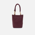 Burgundy handbag with braided handle on a light gray background