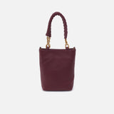 Burgundy handbag with braided handle on a light gray background