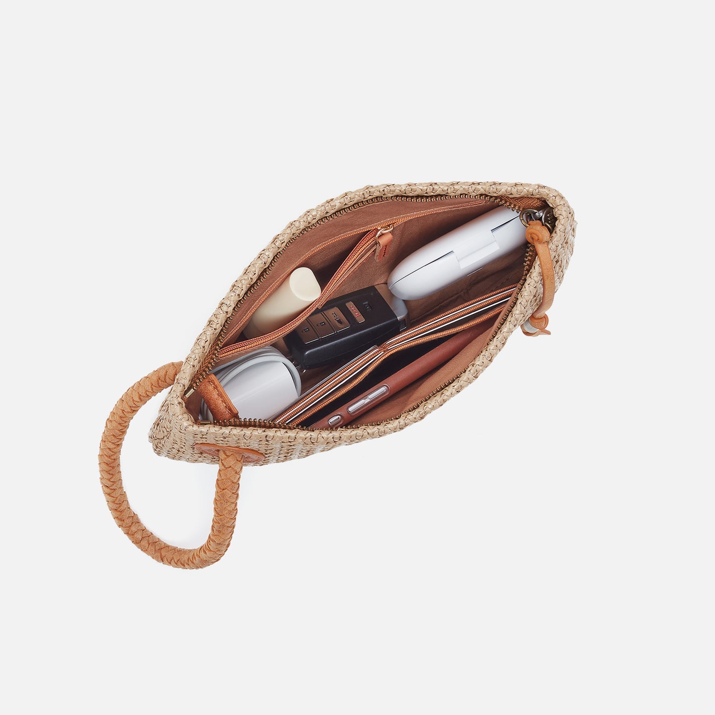 Open woven pouch with cosmetic items on a white background