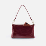 Red leather handbag with a brown patch on a white background